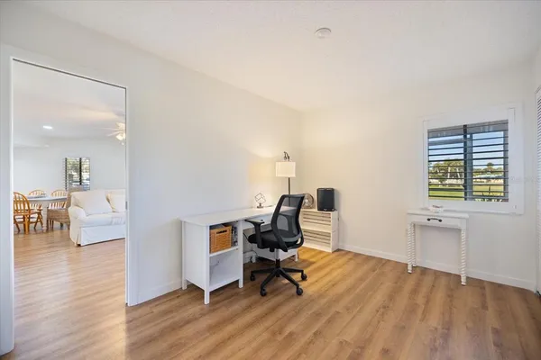 a view of a workspace with furniture and a window
