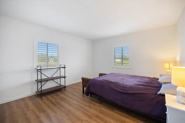 a bedroom with a bed a window and chair