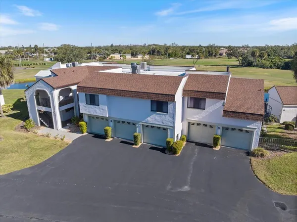 an aerial view of residential houses with outdoor space and ocean view