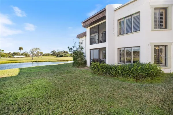 a view of a house with a yard and lake view