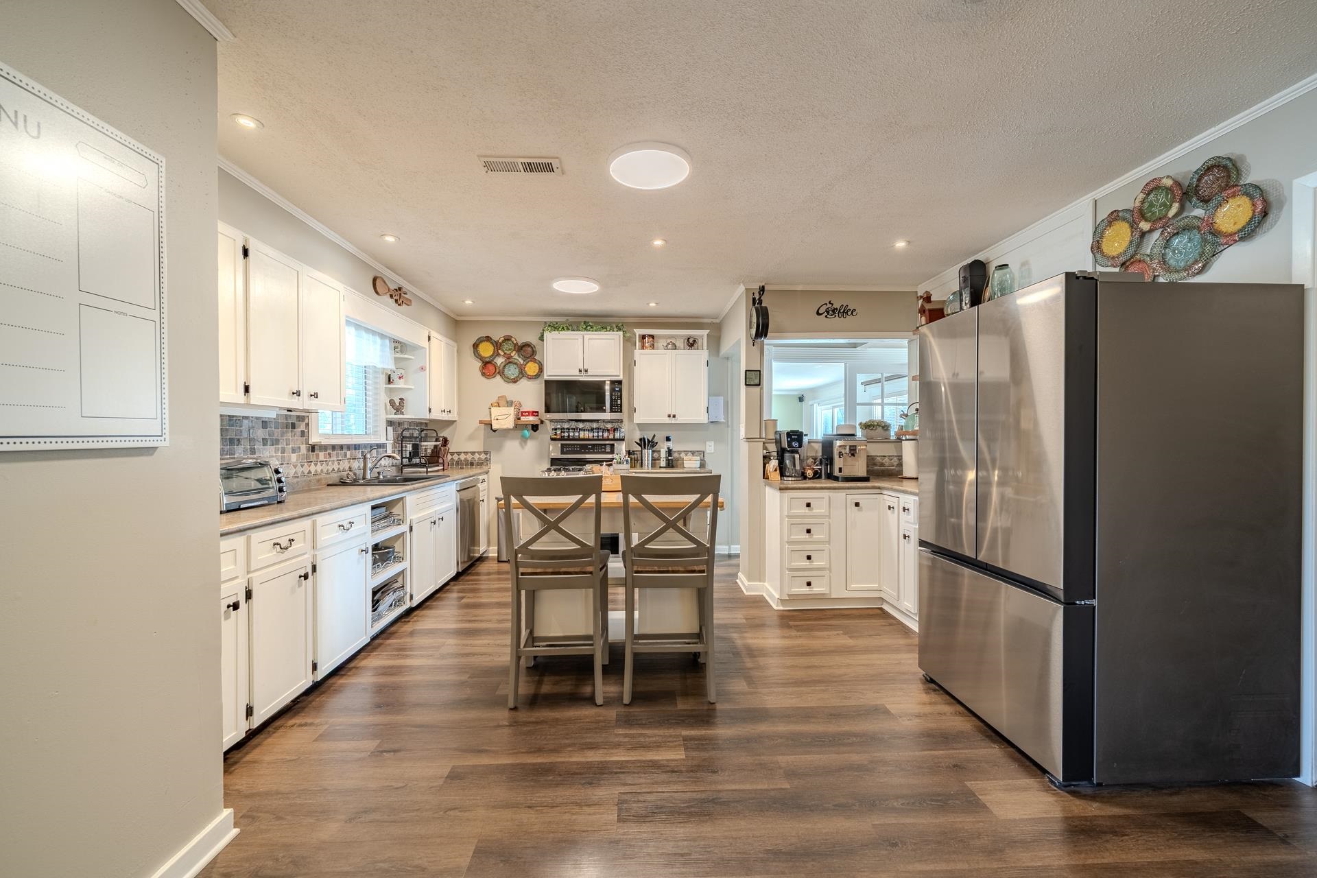 865 Pickett Road Stantonville, TN 38379 - Photo 12 of 40 a kitchen with stainless steel appliances granite countertop a refrigerator oven a stove a sink and white cabinets with wooden floor