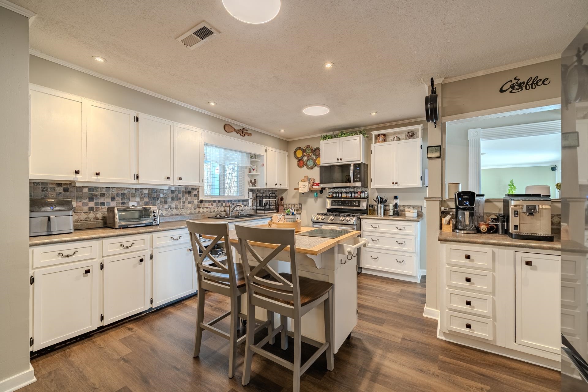 865 Pickett Road Stantonville, TN 38379 - Photo 13 of 40 Kitchen with white cabinetry, a breakfast bar, appliances with stainless steel finishes, a center island, and dark wood-style floors