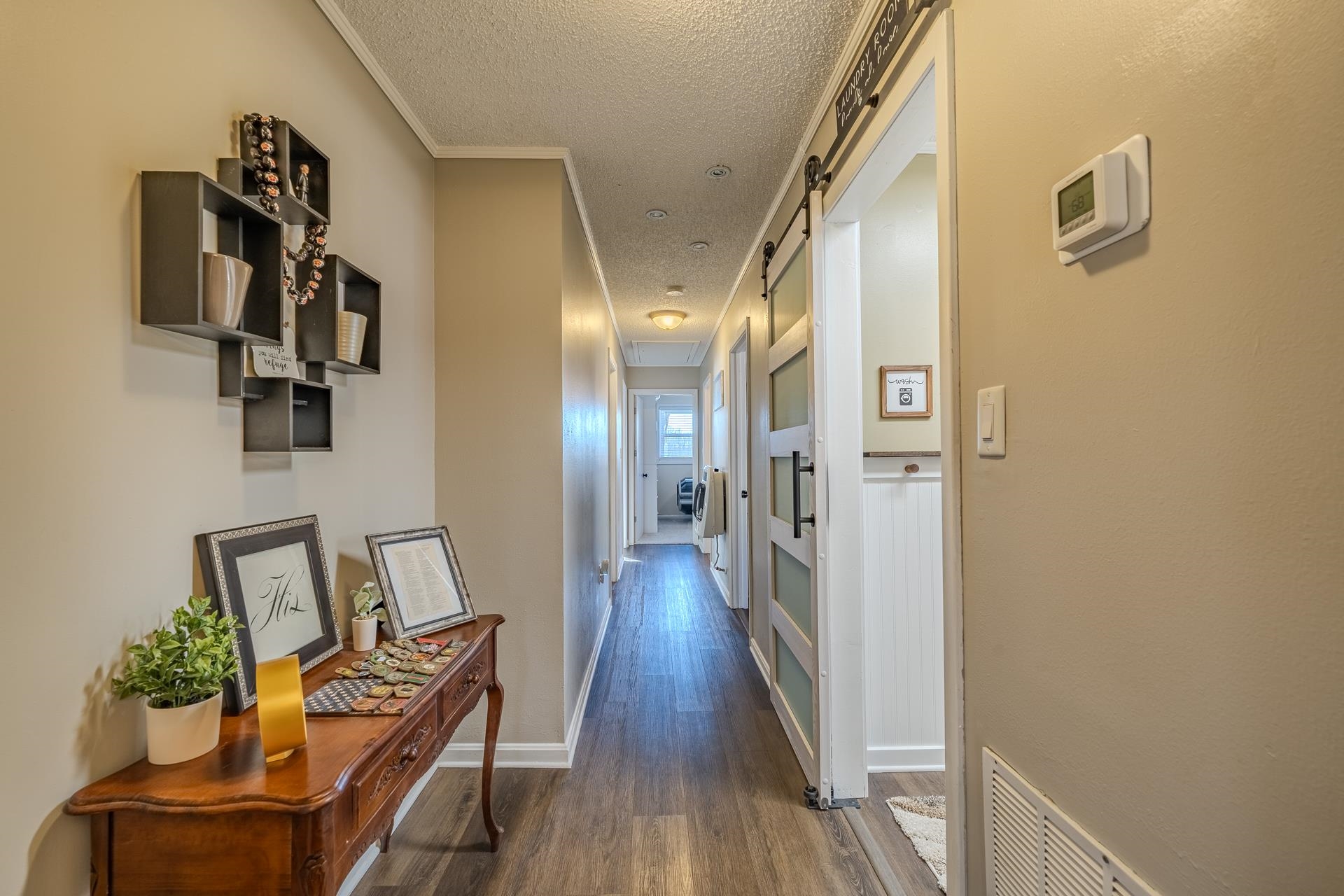 865 Pickett Road Stantonville, TN 38379 - Photo 33 of 40 Corridor with a textured ceiling, a barn door, dark wood-type flooring, and crown molding