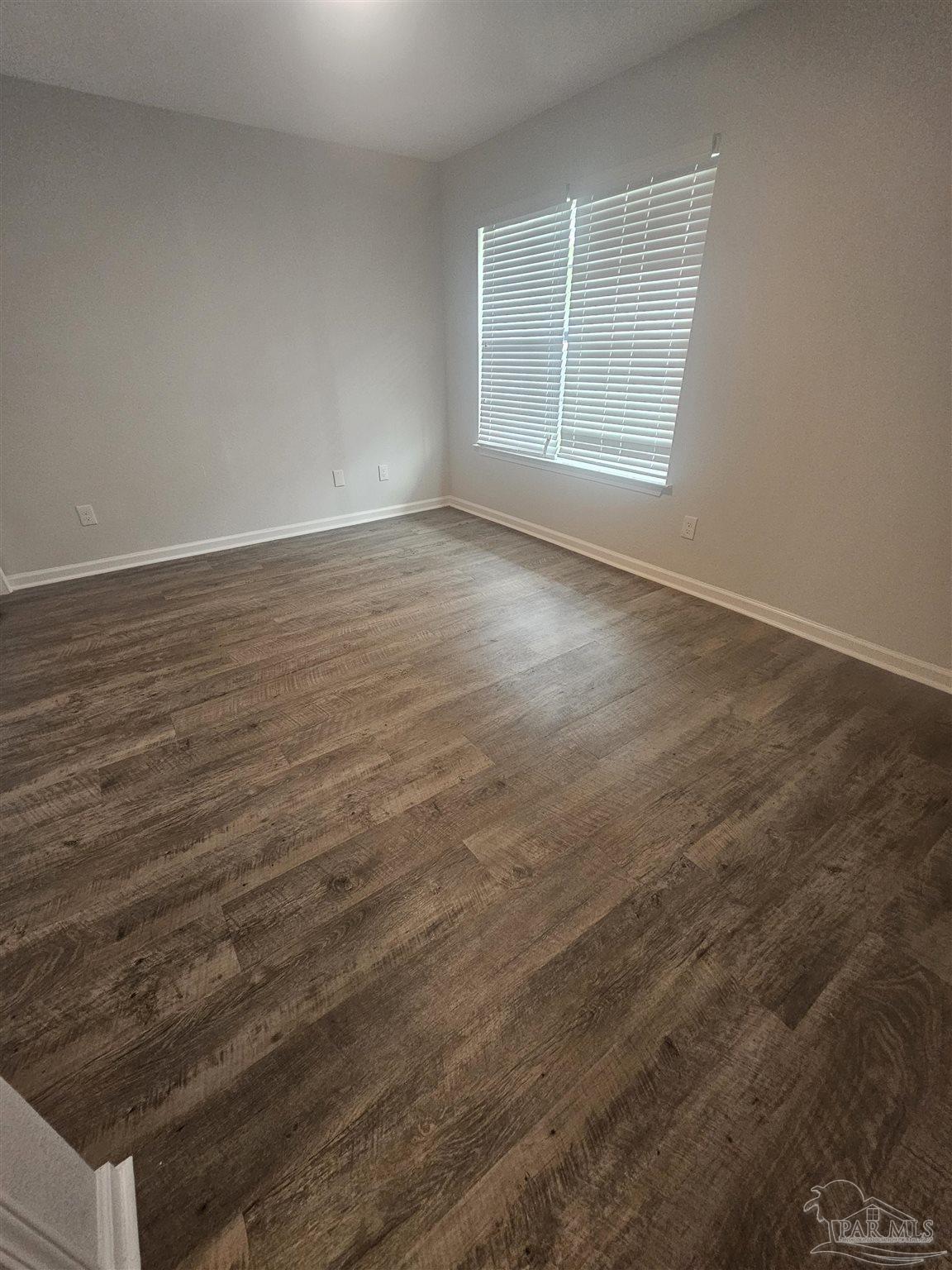 751 Tumbleweed Trail, Unit A Pensacola, FL 32534 - Photo 5 of 13 an empty room with wooden floor and windows
