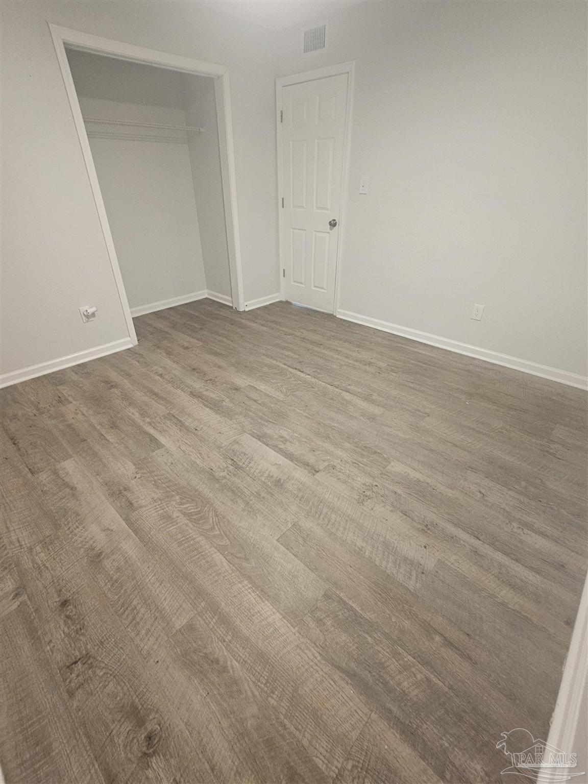 751 Tumbleweed Trail, Unit A Pensacola, FL 32534 - Photo 8 of 13 an empty room with wooden floor