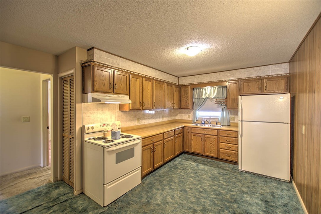 2273 North Fairview Avenue Decatur, IL 62526 - Photo 7 of 24 a kitchen with a stove a refrigerator and white cabinets