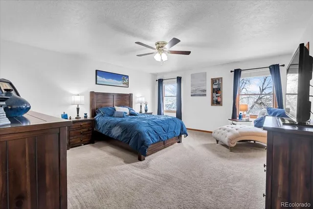 a spacious bedroom with a bed and wooden floor