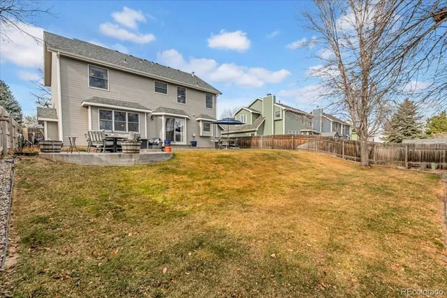 a front view of house with yard and trees in the background