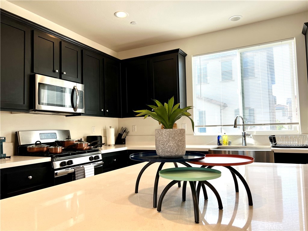 1207 Alpine Circle Baldwin Park, CA 91706 - Photo 4 of 38 a kitchen with a table chairs microwave and cabinets