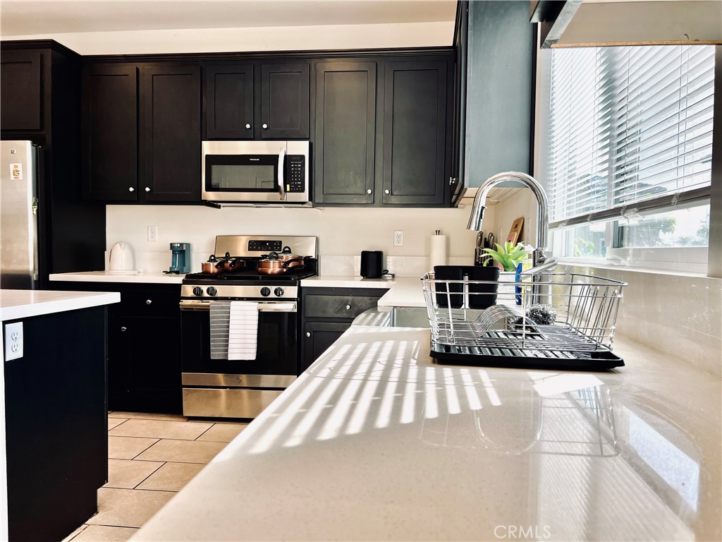 1207 Alpine Circle Baldwin Park, CA 91706 - Photo 6 of 38 a kitchen with granite countertop a stove a sink and a microwave