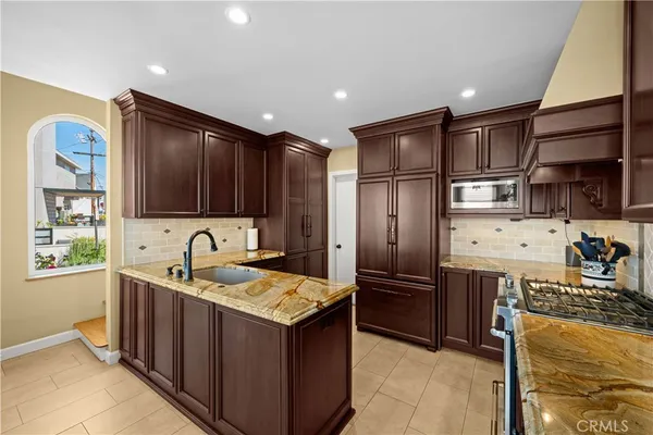a kitchen with stainless steel appliances granite countertop a sink stove and refrigerator