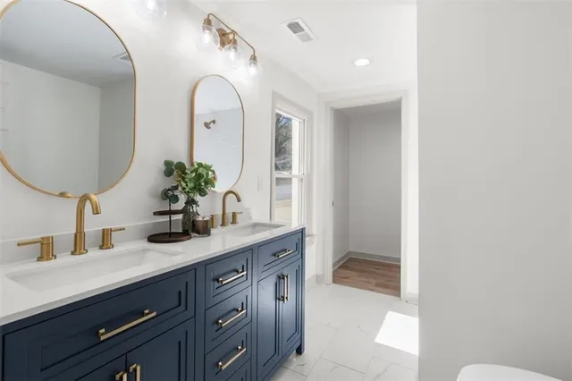a bathroom with a granite countertop sink a toilet and a mirror