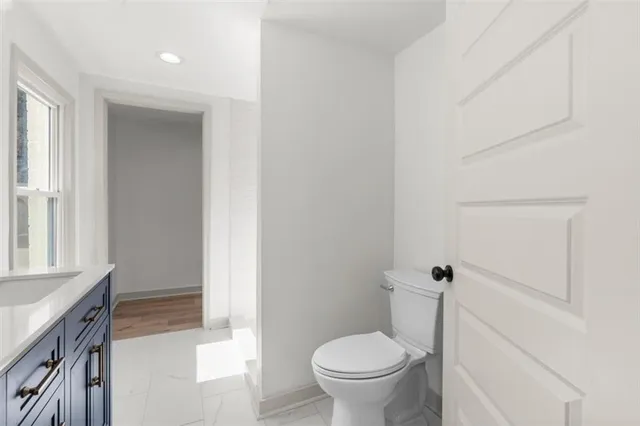 a bathroom with a granite countertop sink toilet and a tub