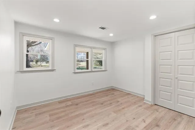 a view of empty room with wooden floor
