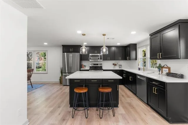 a kitchen with stainless steel appliances granite countertop a sink stove and wooden floor