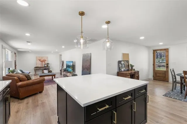 a large kitchen with sink a refrigerator and chairs