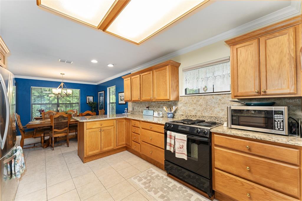 10922 Palmetto Boulevard Alachua, FL 32615 - Photo 13 of 51 a kitchen with stainless steel appliances granite countertop a stove top oven a sink dishwasher and cabinets with wooden floor