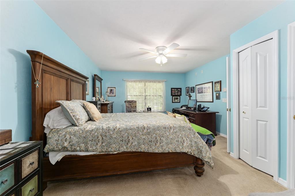 10922 Palmetto Boulevard Alachua, FL 32615 - Photo 19 of 51 a bedroom with a large bed and a chandelier