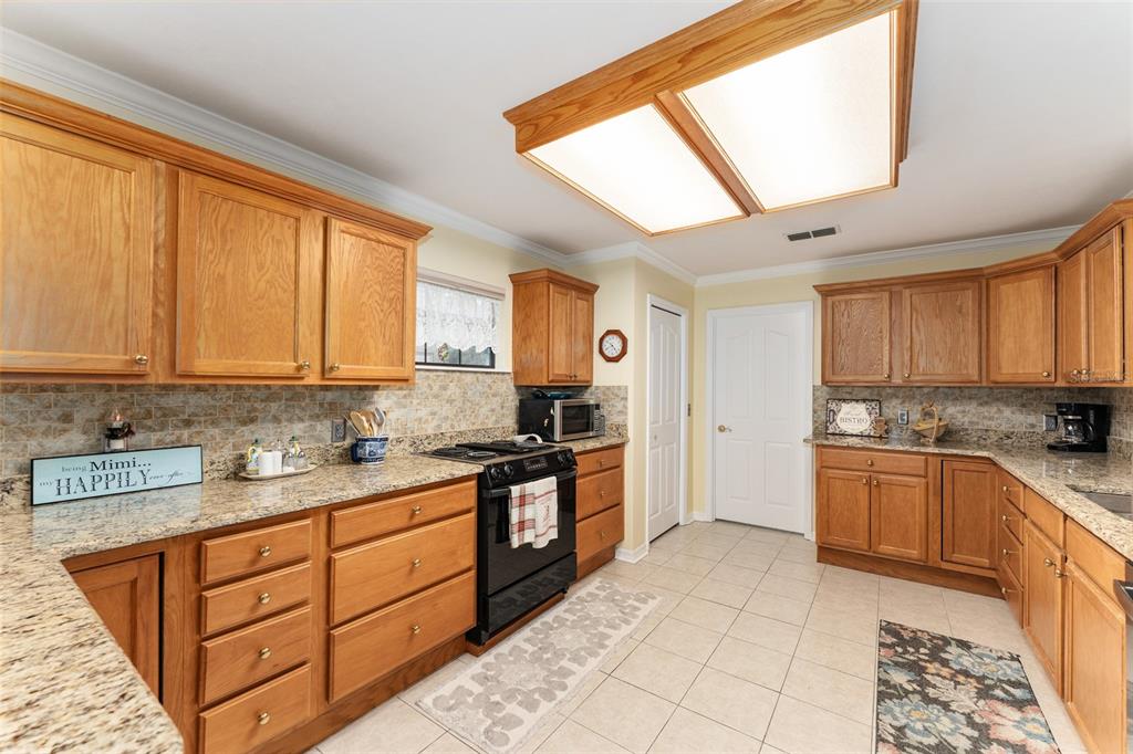 10922 Palmetto Boulevard Alachua, FL 32615 - Photo 10 of 51 a kitchen with stainless steel appliances granite countertop a stove a sink and a microwave