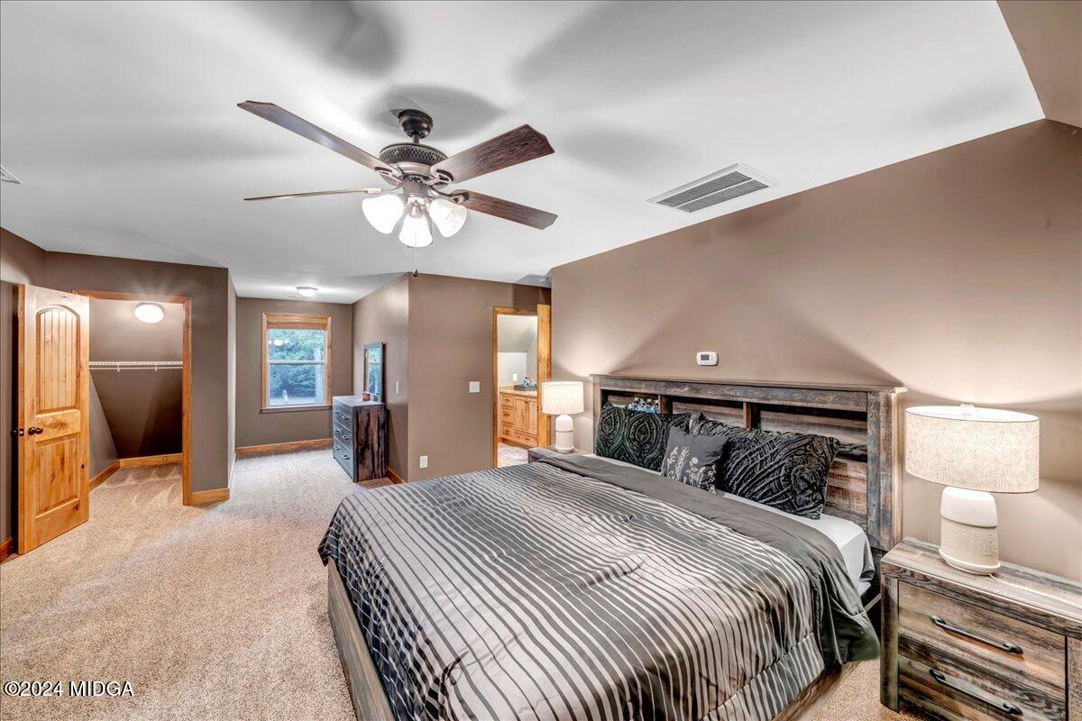 306 Thomson Street Centerville, GA 31028 - Photo 50 of 99 a bedroom with a large bed and a chandelier