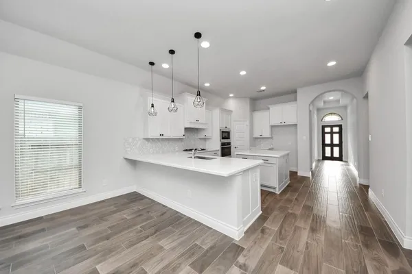 a kitchen with stainless steel appliances cabinets and a wooden floor