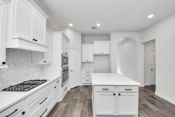 a kitchen with kitchen island a stove a sink and a refrigerator