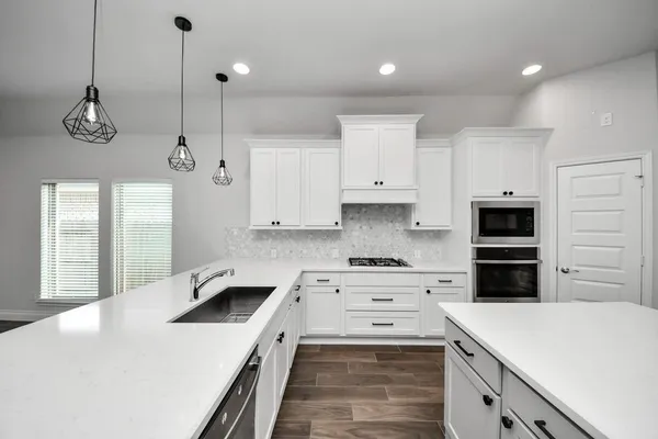 a kitchen with granite countertop white cabinets and white appliances
