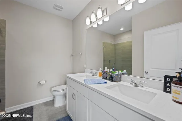 a bathroom with a sink a toilet and a mirror