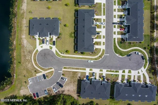 an aerial view of residential houses with outdoor space and parking