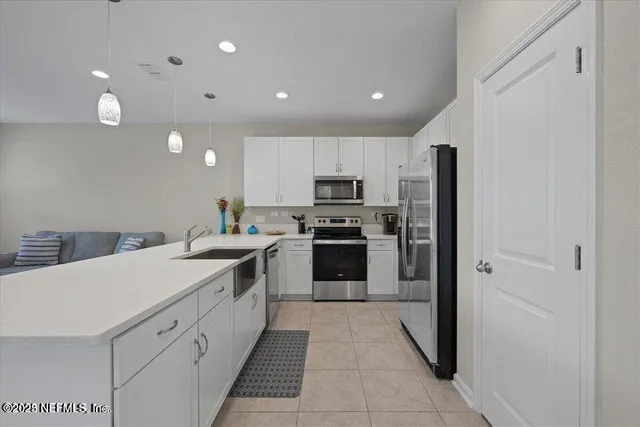 a kitchen with a sink a counter top space stainless steel appliances and cabinets