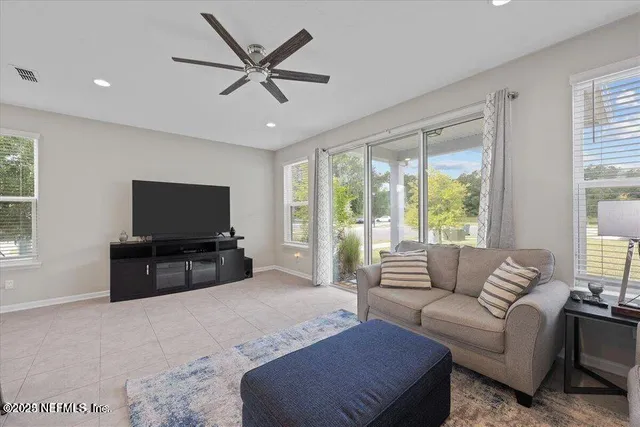 a living room with furniture a flat screen tv and a large window
