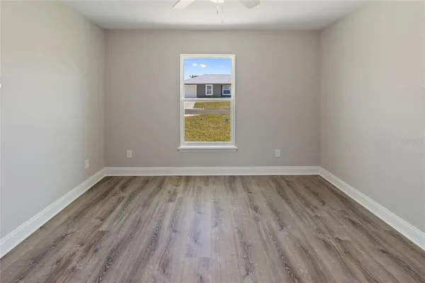an empty room with a window and wooden floor