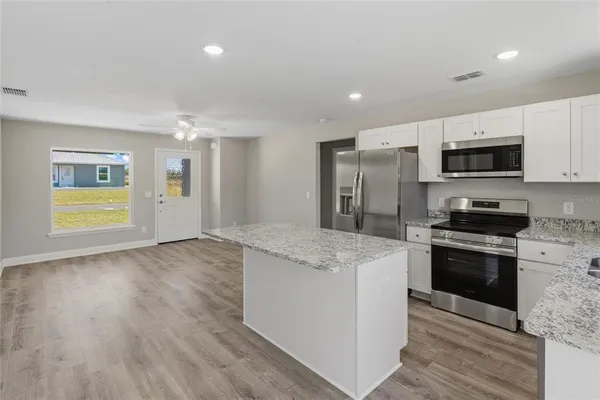 a kitchen with stainless steel appliances granite countertop a stove a sink and a refrigerator