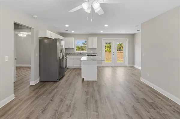 a view of a kitchen with wooden floor and a refrigerator