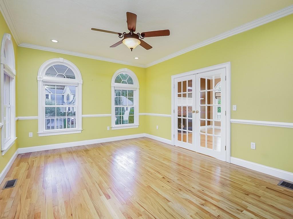 24 Village Road Pepperell, MA 01463 - Photo 12 of 40 a view of a livingroom with wooden floor a ceiling fan and windows