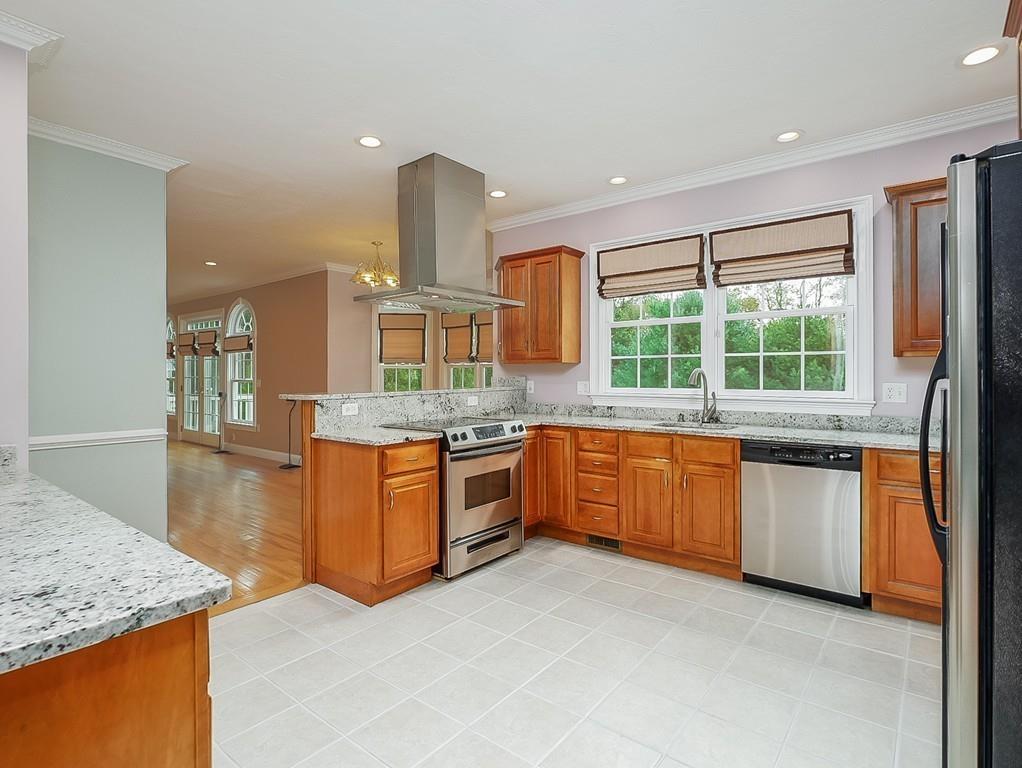 24 Village Road Pepperell, MA 01463 - Photo 19 of 40 a kitchen with stainless steel appliances granite countertop wooden cabinets and a granite counter tops with a large window