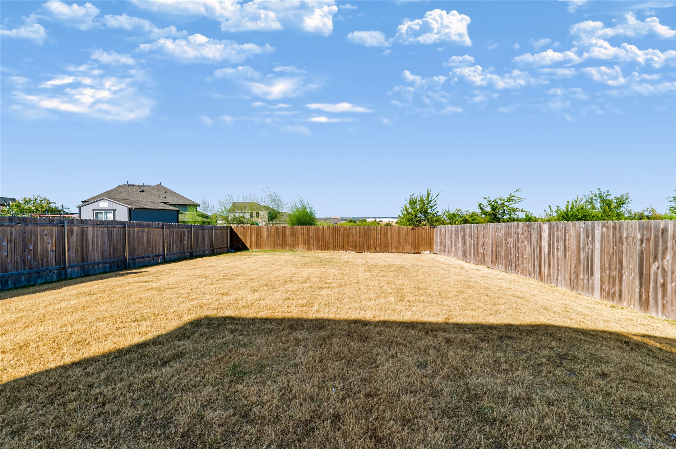 4600 Alfano Loop Round Rock, TX 78665 - Photo 27 of 34 Backyard featuring an expansive fenced lawn and plenty of room for outdoor enjoyment.