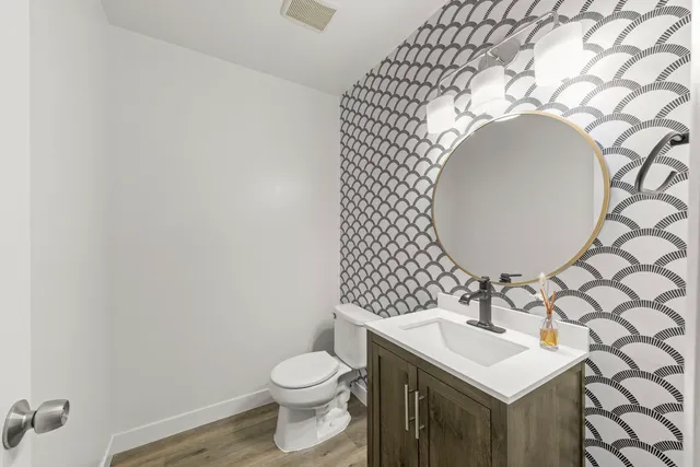 a bathroom with a sink mirror vanity and toilet