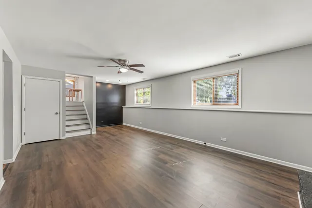 a view of empty room with wooden floor and window
