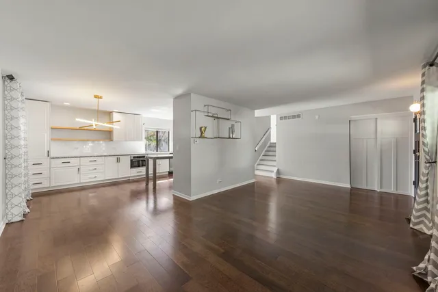 a view of a kitchen with a fridge and wooden floor