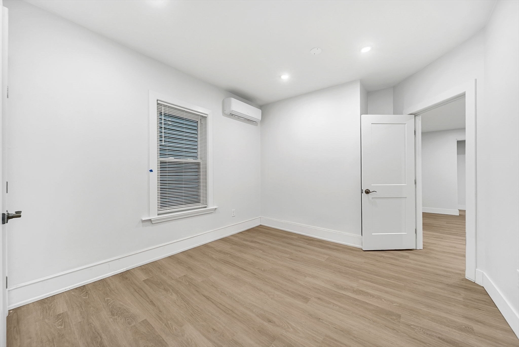 92 Willow Street, Unit 2 Cambridge, MA 02141 - Photo 14 of 20 an empty room with wooden floor and windows