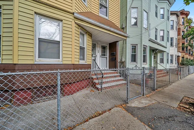 a view of a brick building with a bench in front of building