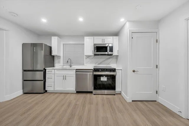 a kitchen with a refrigerator and a stove top oven