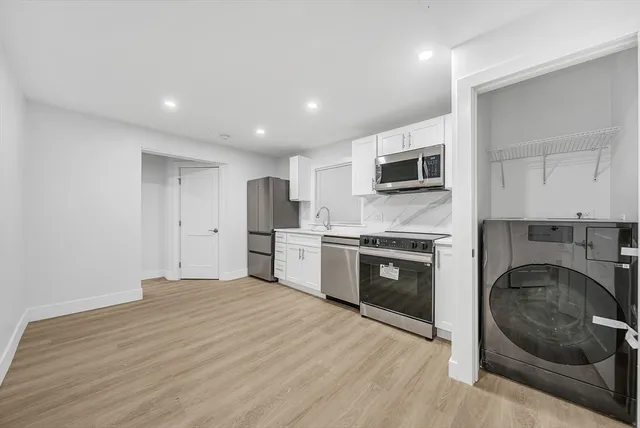 a large kitchen with stainless steel appliances granite countertop a stove and a sink