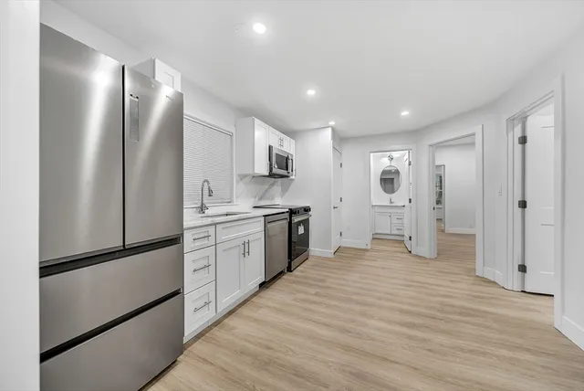 a kitchen with white cabinets and stainless steel appliances