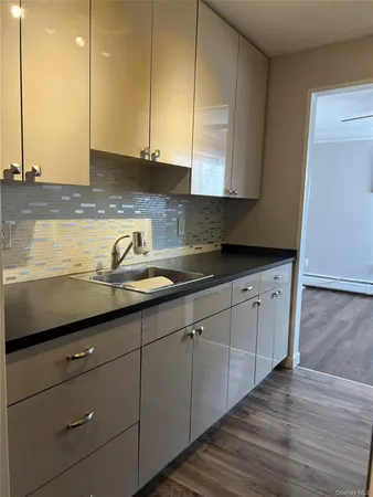 a kitchen with granite countertop white cabinets and sink