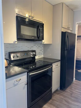 a kitchen with stainless steel appliances granite countertop a stove microwave and refrigerator