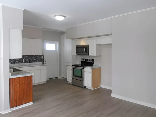 a kitchen with granite countertop white cabinets and stainless steel appliances