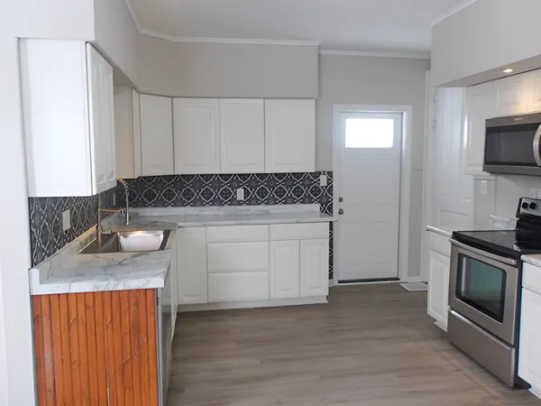 a kitchen with granite countertop a stove and a sink