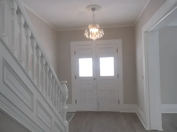 a view of a chandelier in big room with wooden floor
